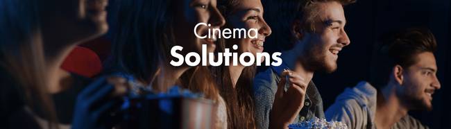 人们一边吃爆米花，一边观看演出。文字为：'Cinema Solutions'